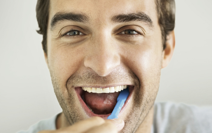 Erwachsener Mann Zähne putzen und zeigen